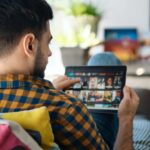 Man Choosing Movie For Streaming On Tablet